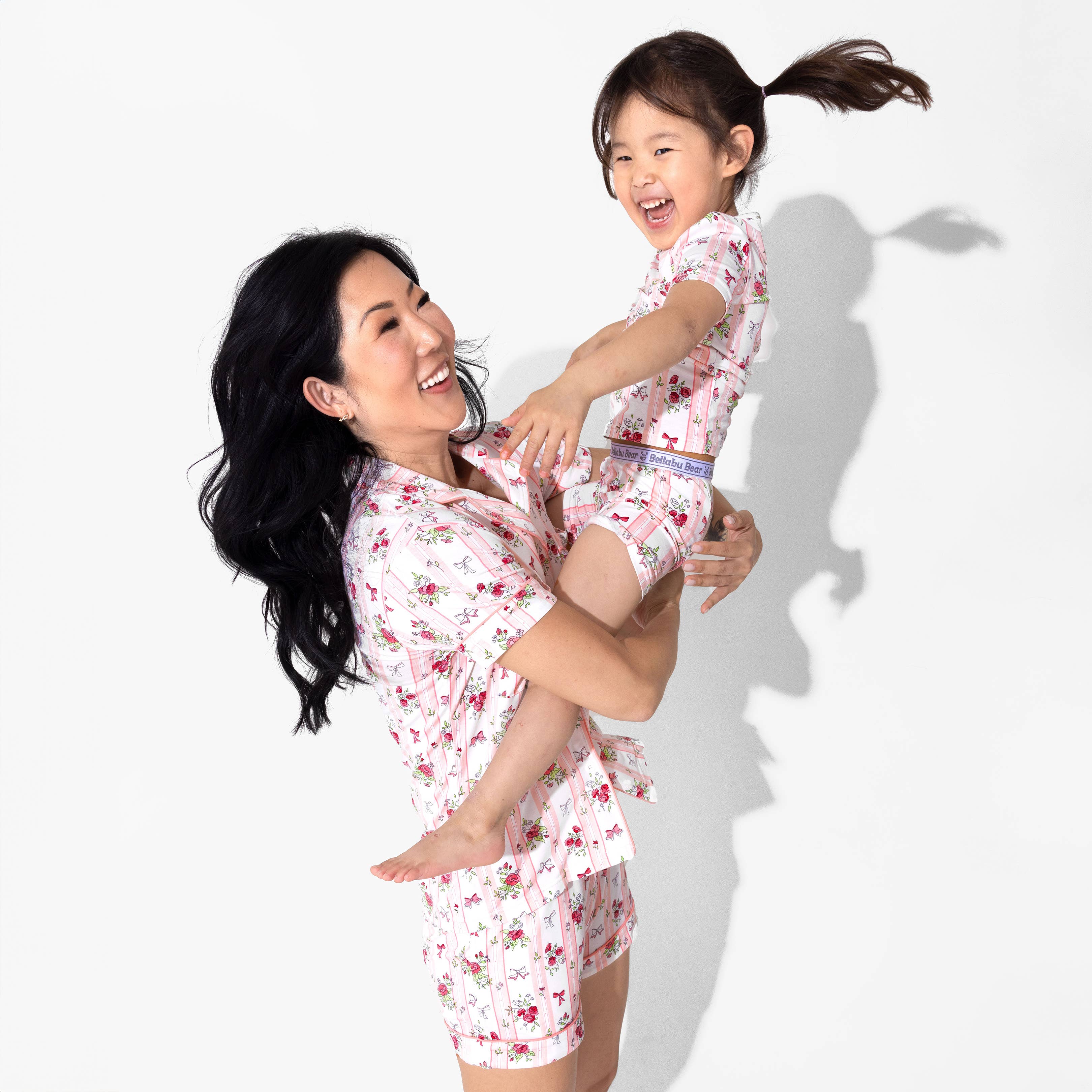 Woman and child in matching bamboo floral pajamas on a white background