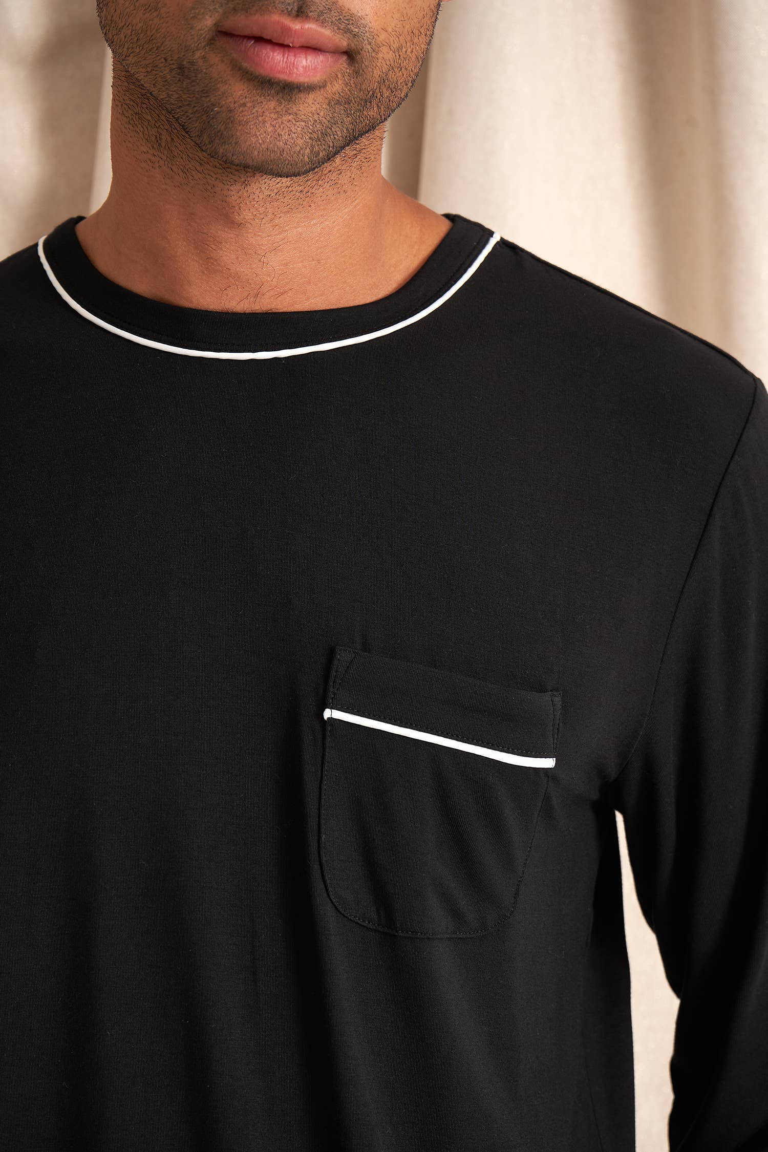 Men's black bamboo pajama set with long-sleeve top and full-length pants. White drawstring and piping detail. Front shirt pocket and pant pockets