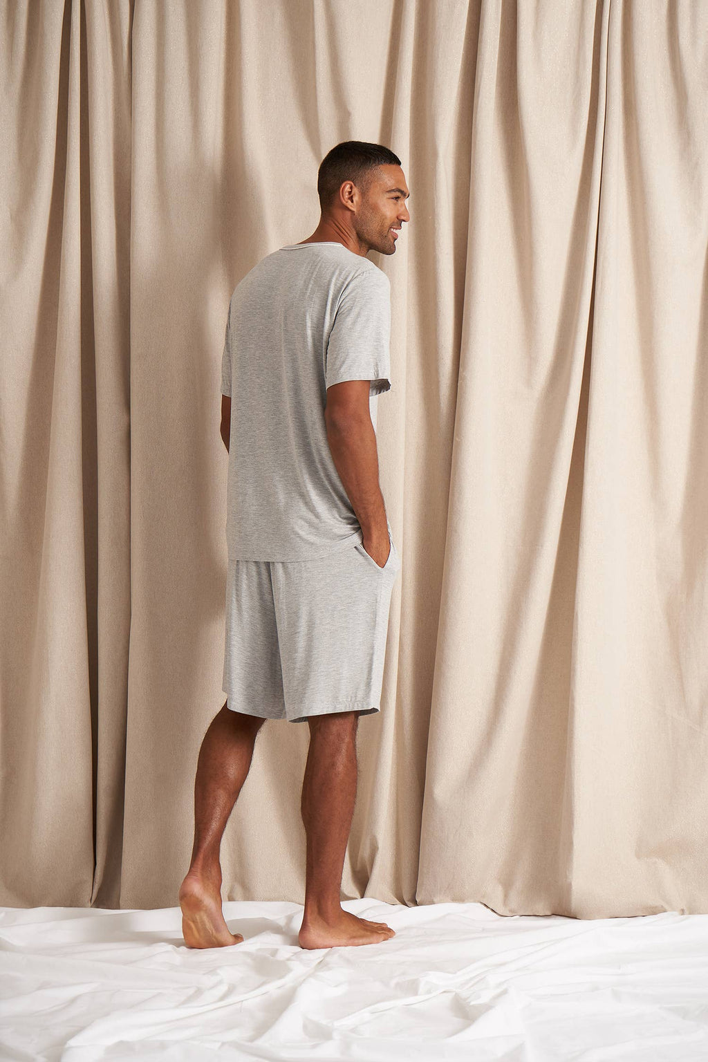 Men's bamboo pajama short set in grey matching shorts with drawstring and side pockets. Top is a t-shirt style with 3 buttons
