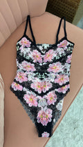 Women's pink and white floral teddy bodysuit with adjustable straps flat lay