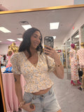 Women's floral ruffle vneck top with puffy sleeves on model close up
