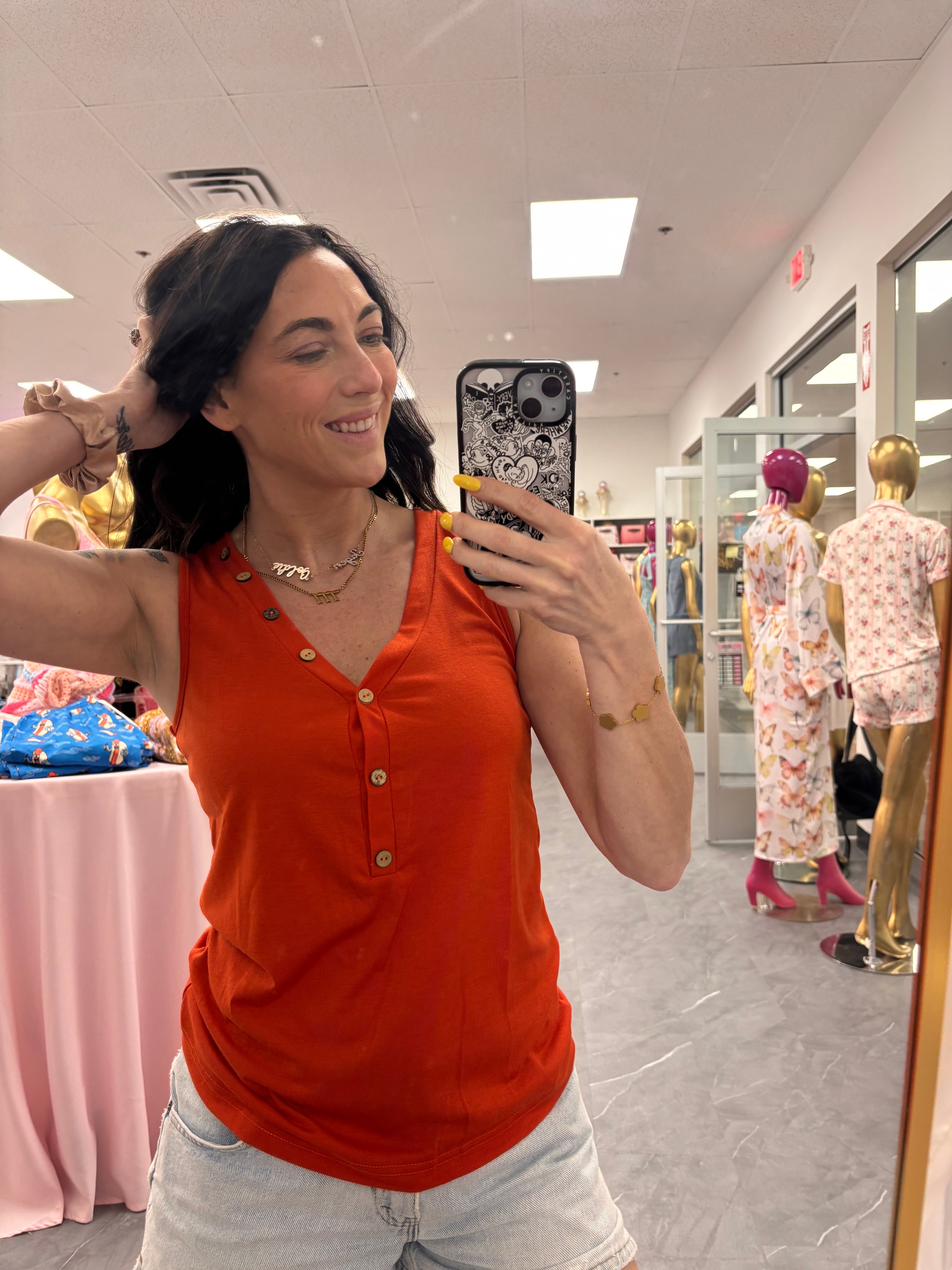 Women's orange vneck tank top with button model close up