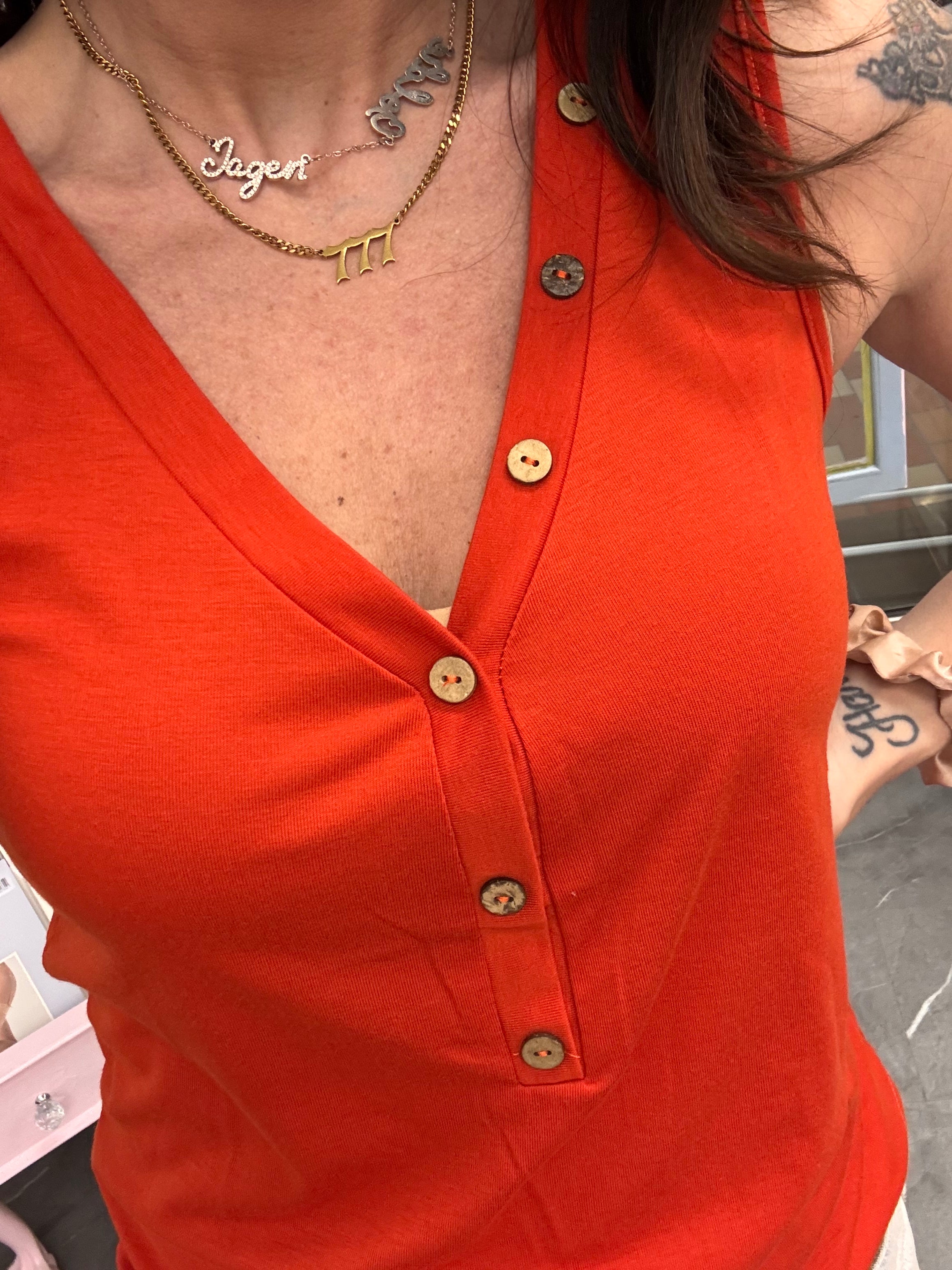 Women's orange v-neck tank top with button details close up