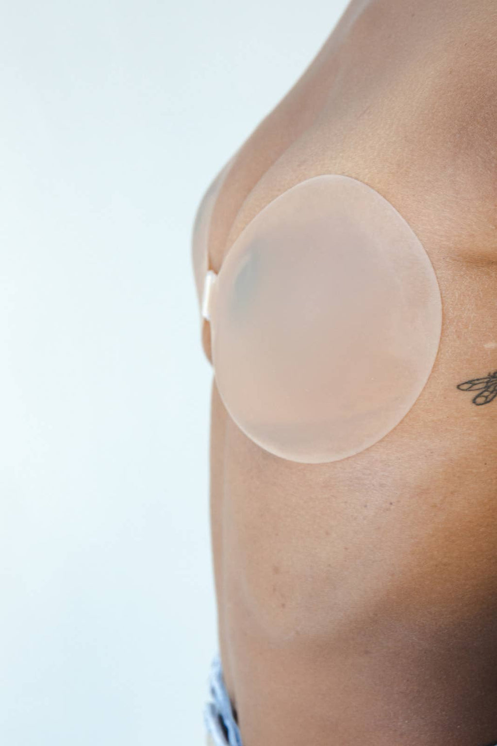 Womens adhesive reusable sticky bra nude with front clasp on model side view
