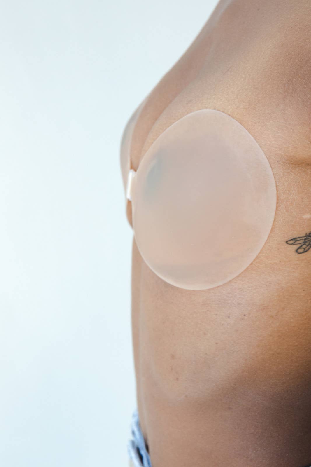 Womens adhesive reusable sticky bra nude with front clasp on model side view