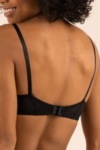 A woman wearing a black demi-coverage bra with soft mesh details and memory foam cups.