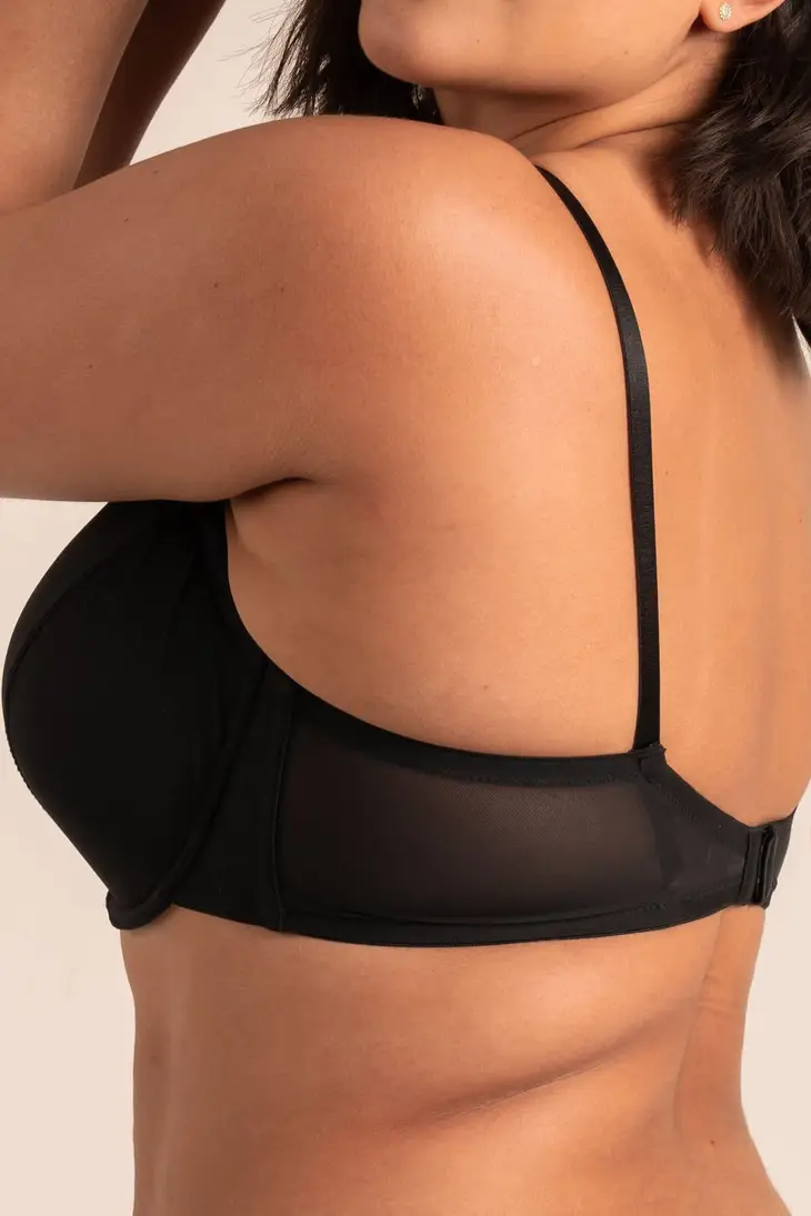 A woman wearing a black demi-coverage bra with soft mesh details and memory foam cups.