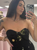Women's black floral romper jumpsuit with flared legs and removable straps. Silicone around top to help hold in place on model