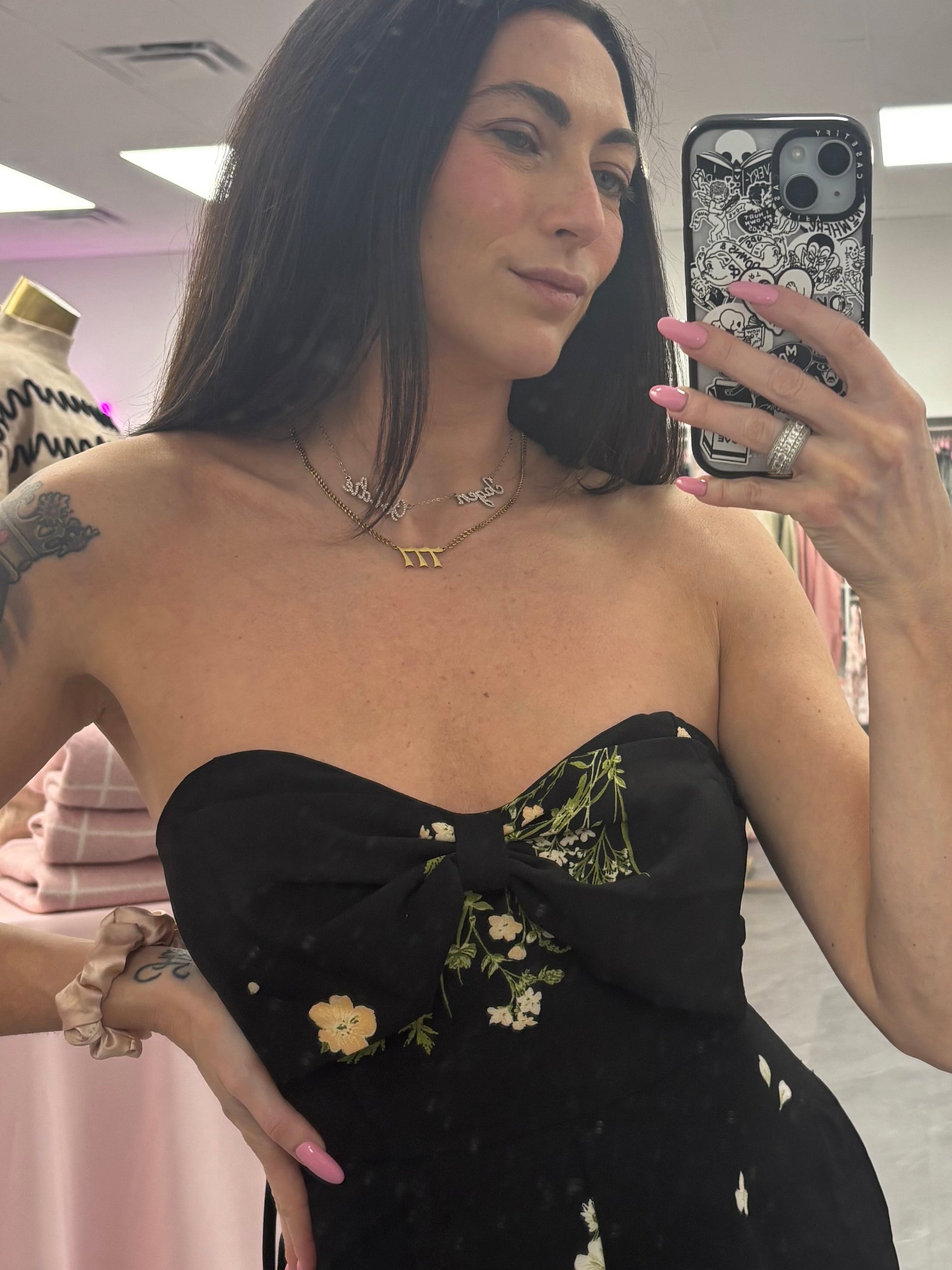 Women's black floral romper jumpsuit with flared legs and removable straps. Silicone around top to help hold in place on model
