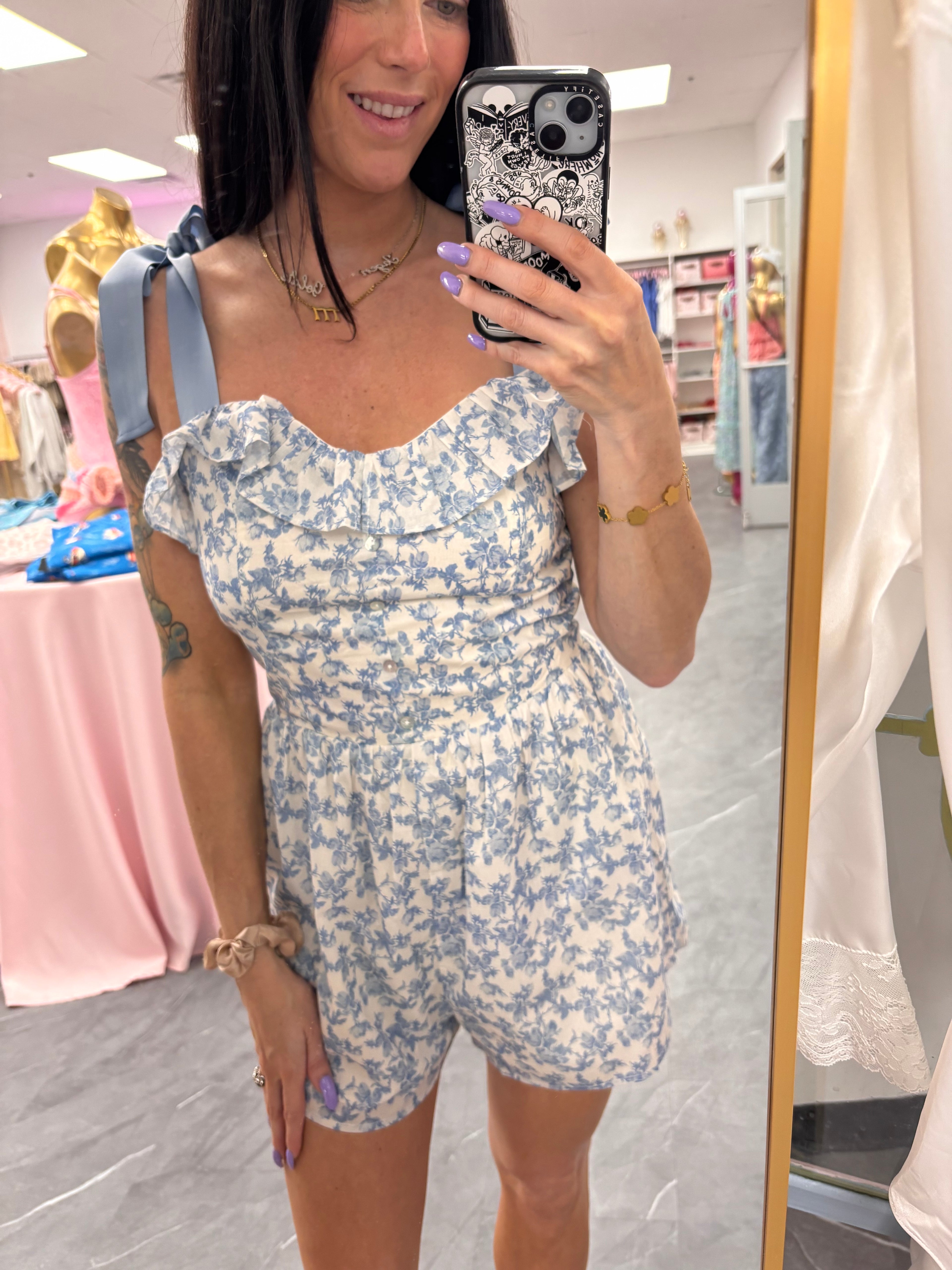 Women's blue floral romper with bow tie straps on model