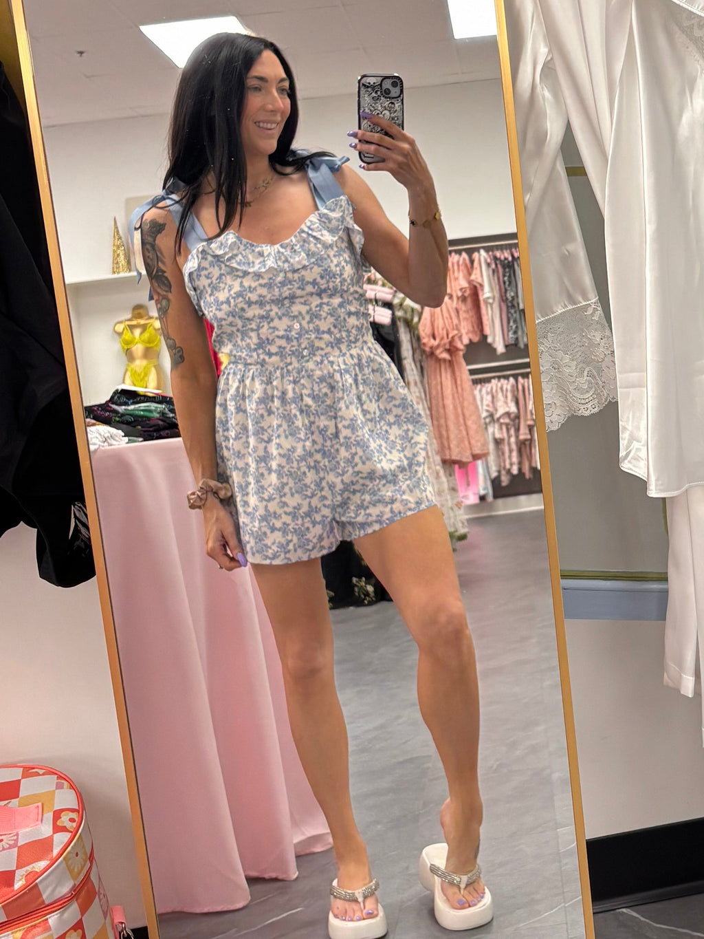 Women's blue floral romper with bow tie straps on model