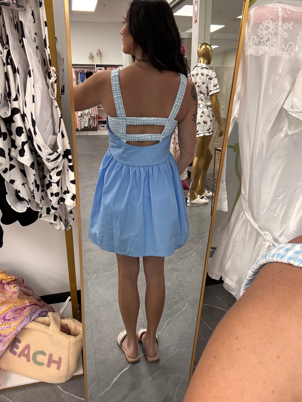 Women's blue gingham athletic dress with shorts underneath and pockets on model back