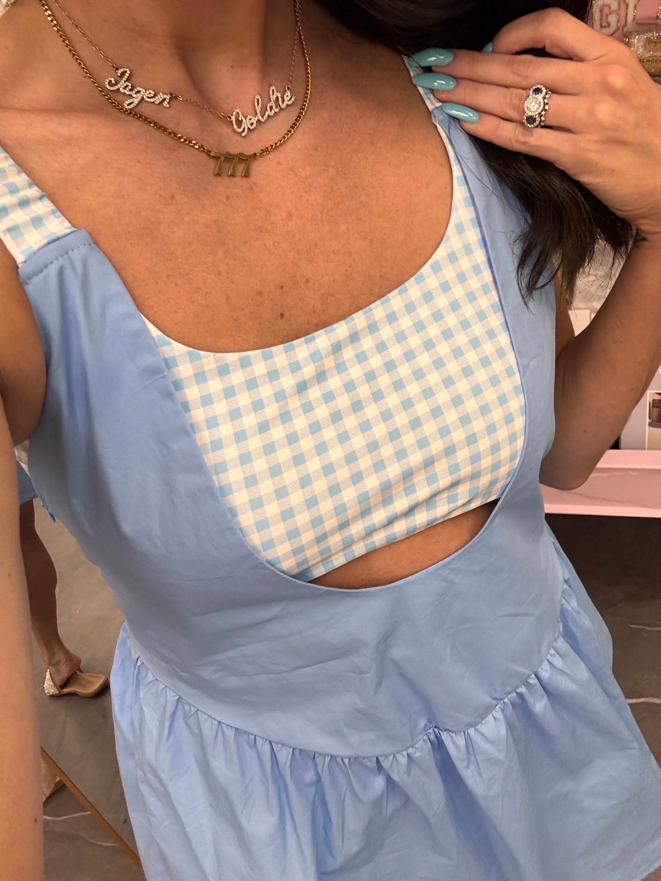 Women's blue gingham athletic dress with shorts underneath and pockets on model front