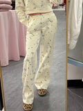 Women's cream flared sweatpants with martini and olives stretchy waistband and pockets on model front view
