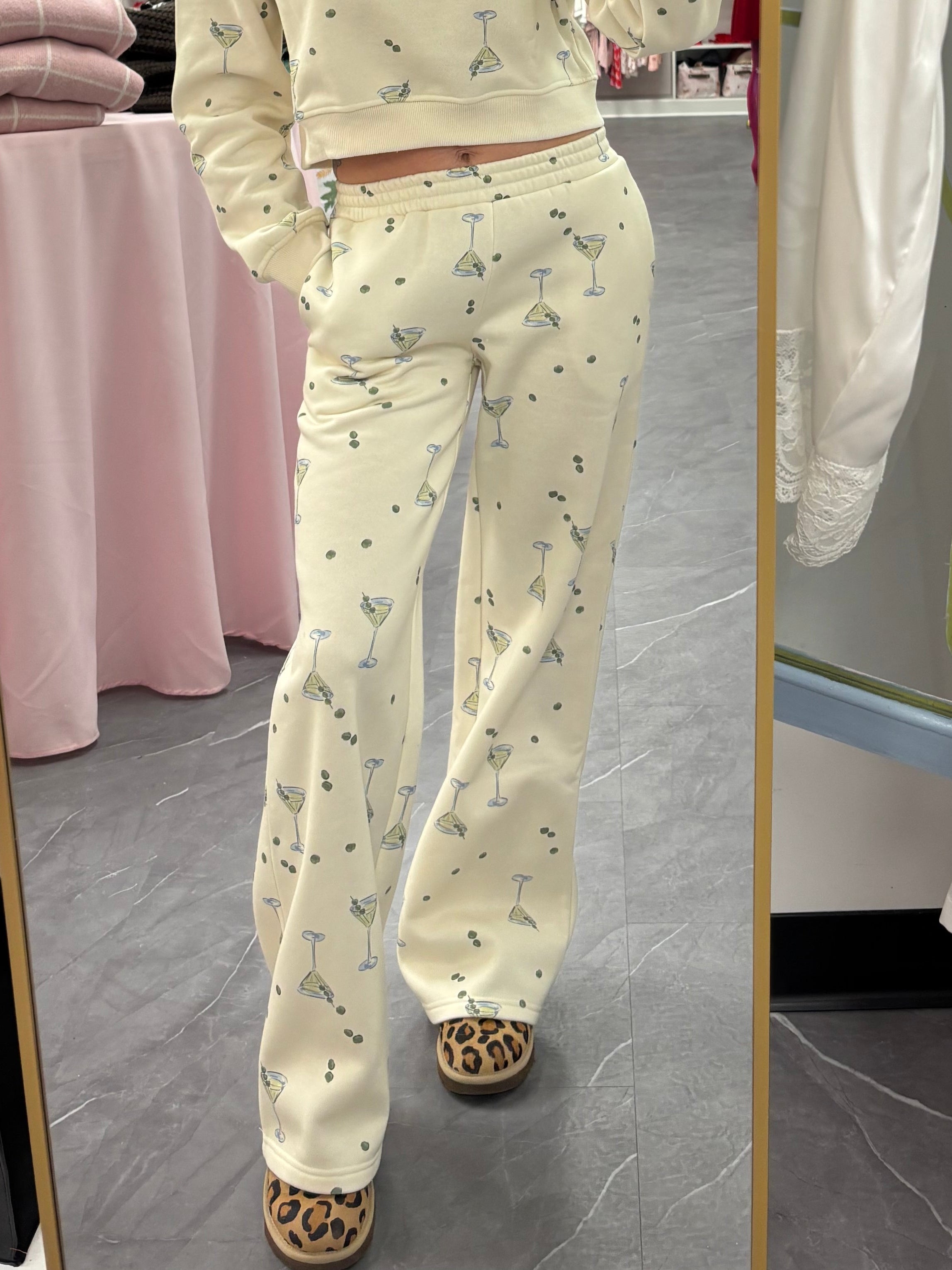 Women's cream flared sweatpants with martini and olives stretchy waistband and pockets on model front view