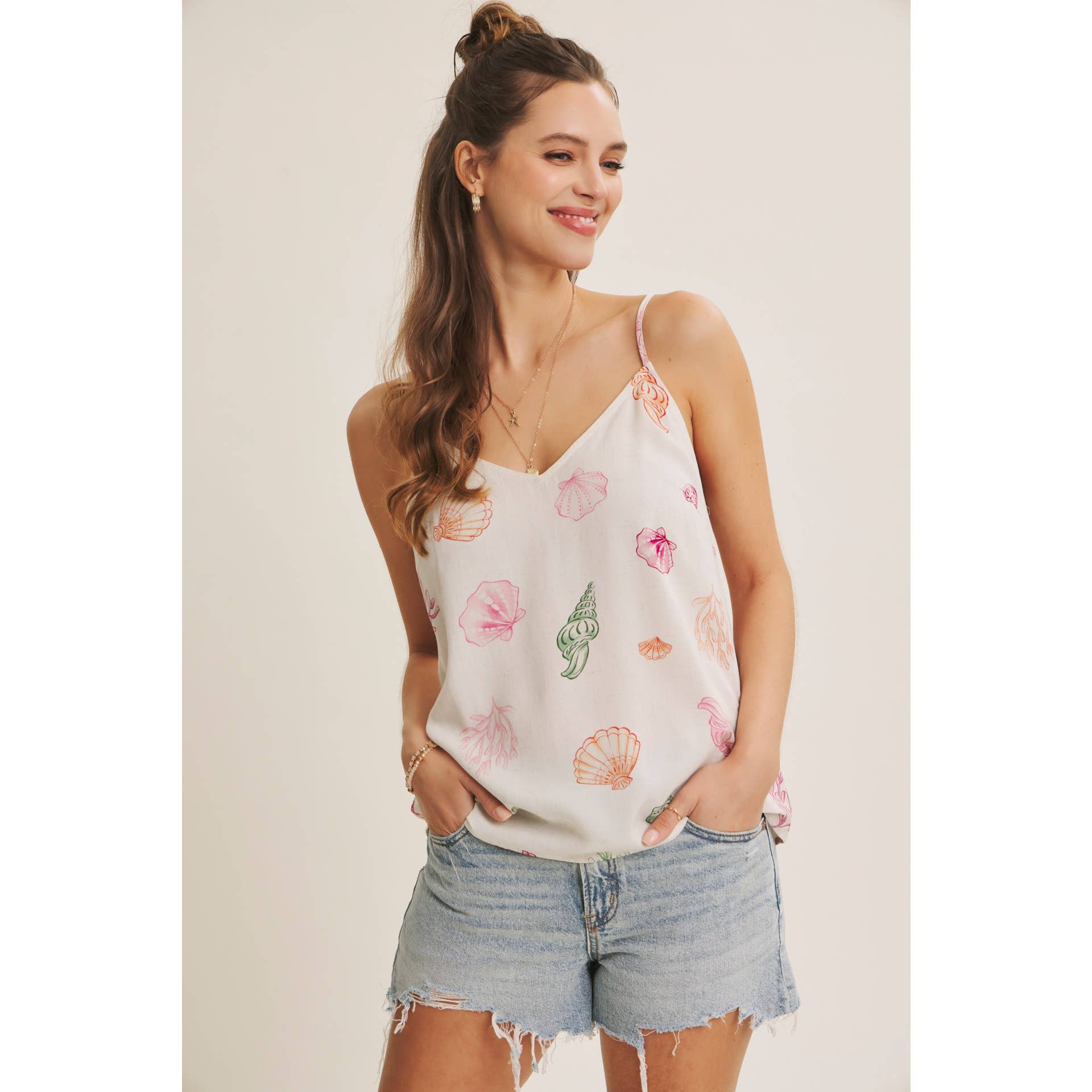 Women's cream tank top with seashells in different shapes and colors. Adjustable strap and v neck line