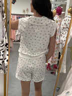 Women's white quarter zip sleeveless floral two piece set back details on model