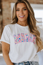 A woman wearing a white graphic tee with leopard print and the word 'mama' embroidered on the front.