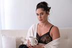 A black and nude nursing bralette with delicate lace detailing, featuring adjustable straps and a hook-and-eye closure on model lifestyle shoot
