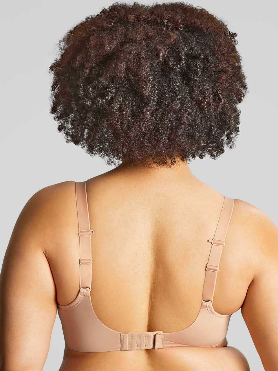 A woman wearing panache elegance beige, moulded cup bra with adjustable straps.