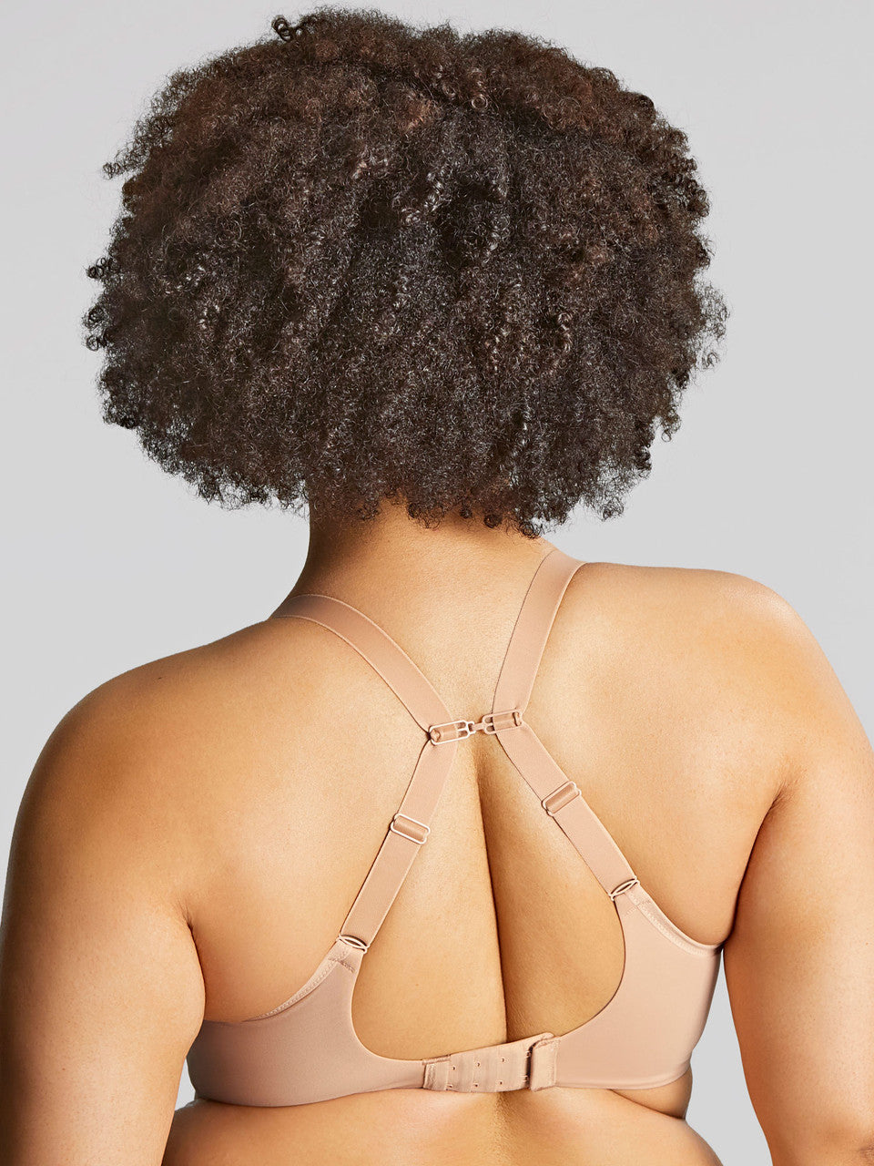 A woman wearing panache elegance beige, moulded cup bra with adjustable straps.