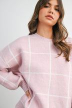 Women's pink checkered knit sweater on model front