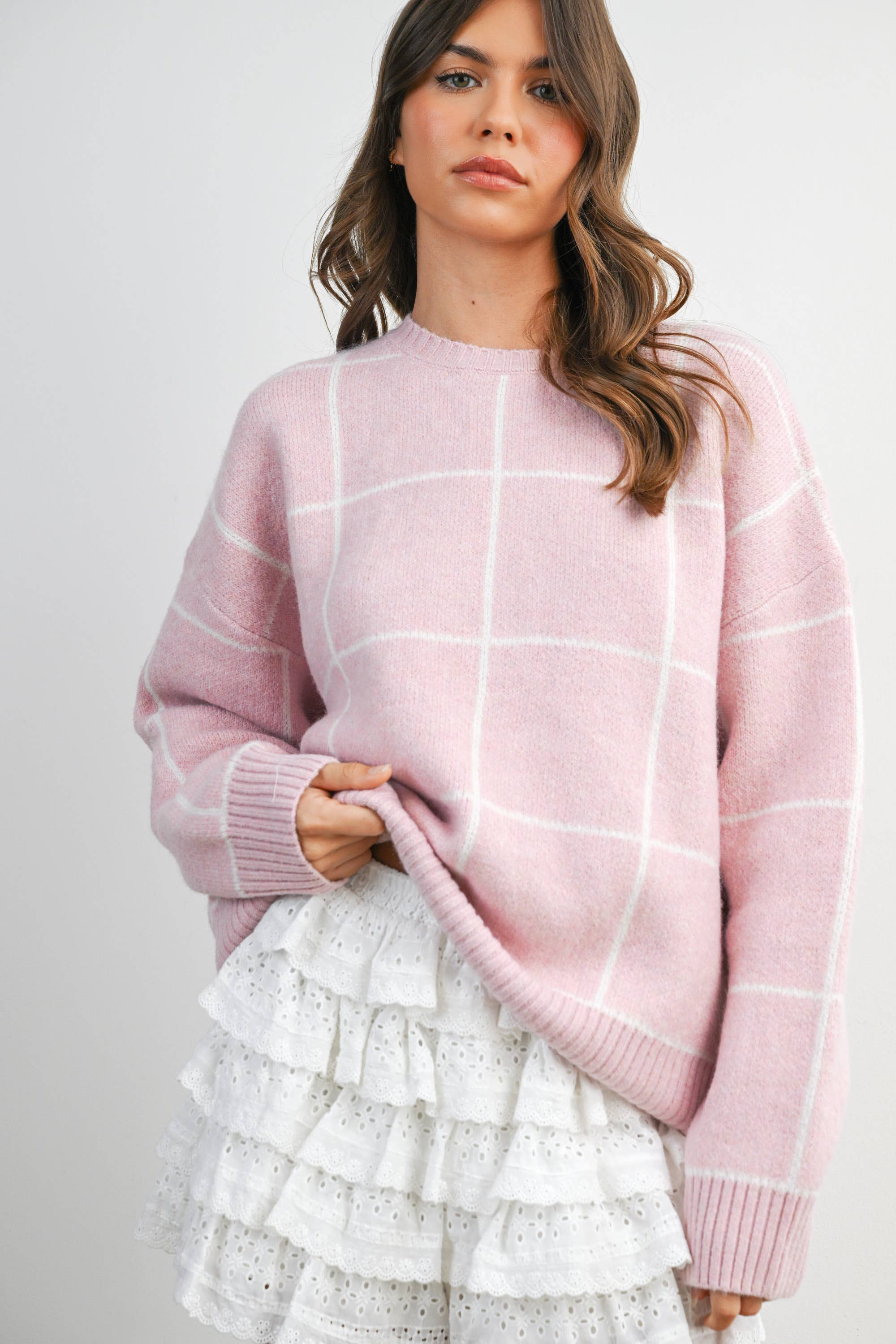 Women's pink checkered knit sweater on model front