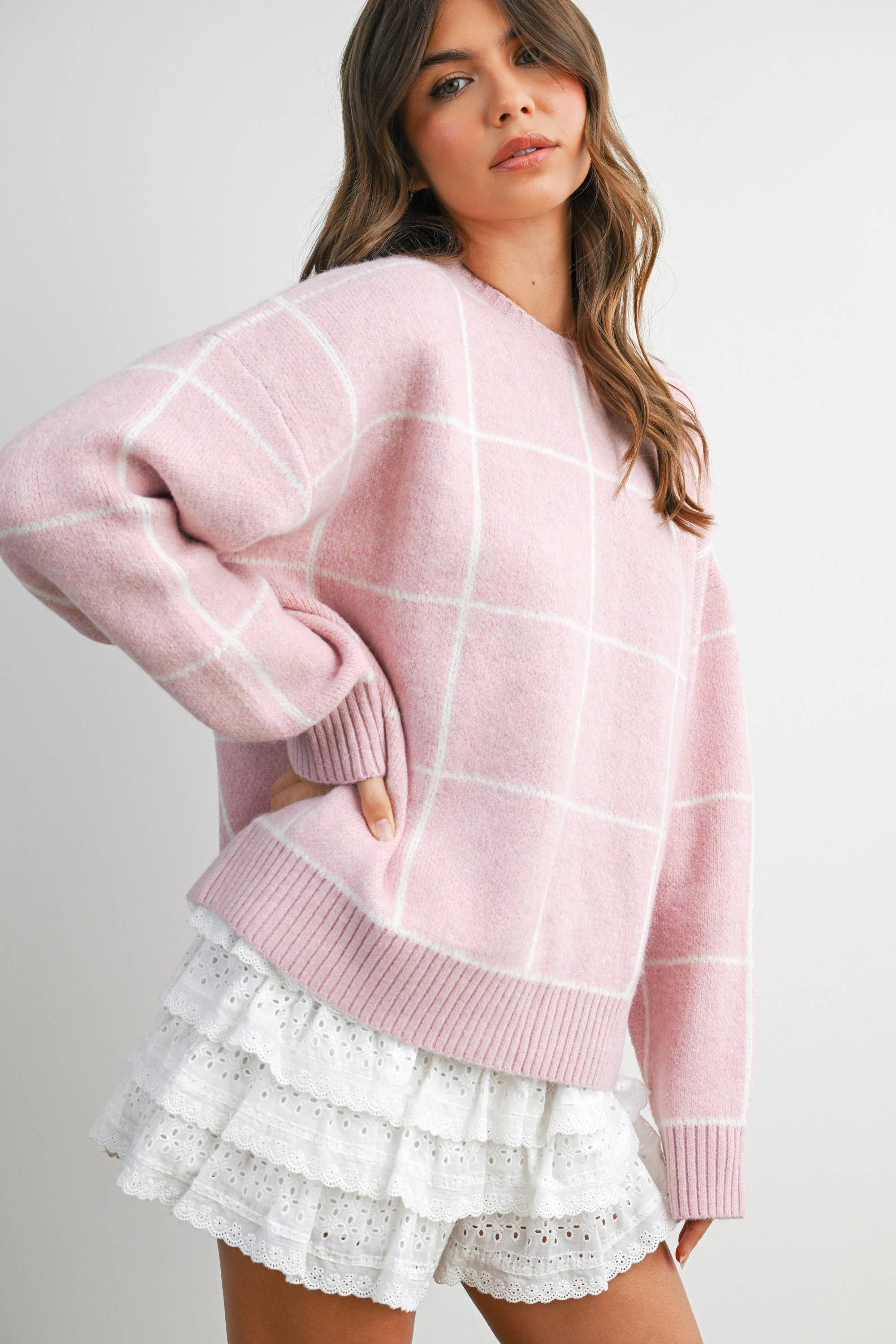 Women's pink checkered knit sweater on model front