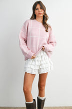 Women's pink checkered knit sweater on model front