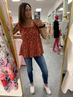 Women's red floral flowy tank top on model