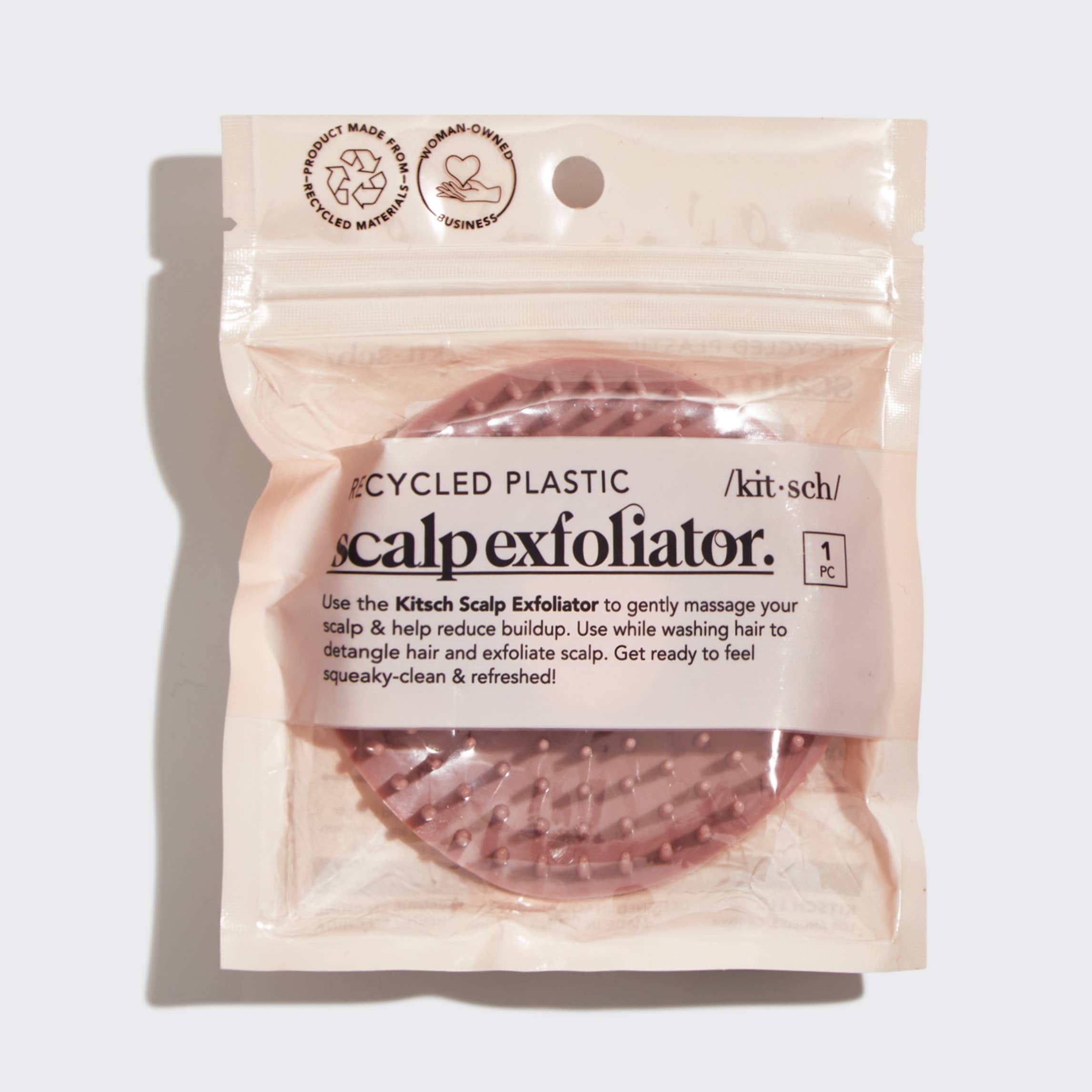 A terracotta-colored scalp exfoliator with soft, flexible bristles, designed for gentle scalp massage and hair detangling.