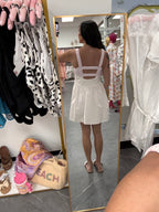 Womens white and pink gingham athletic dress with romper shorts underneath on model