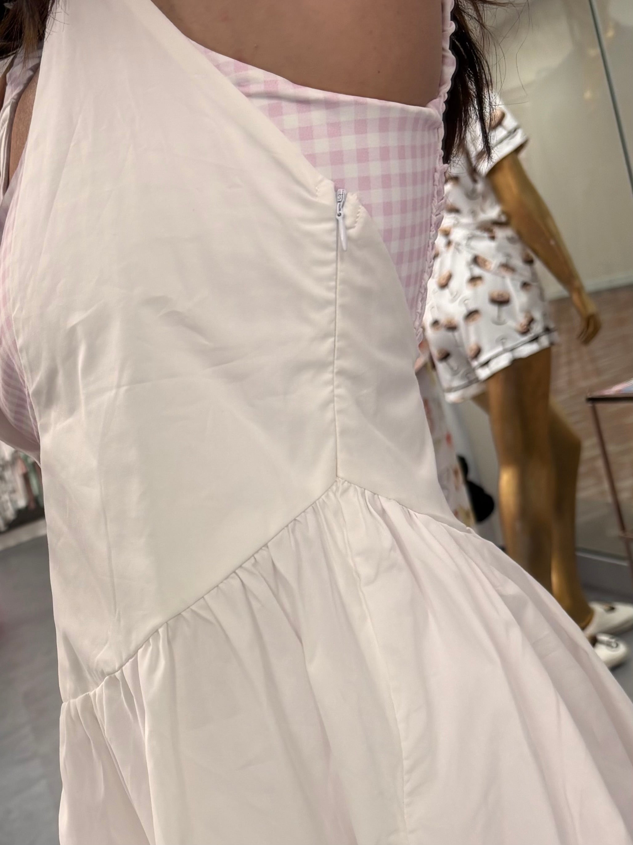 Womens white and pink gingham athletic dress with romper shorts underneath on model zipper detail