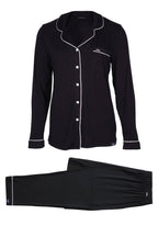 Flat lay of Black bamboo pajama pant set with white trim and buttons. Front pocket